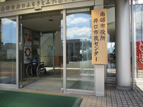 「南砺市役所井口市民センター」と書かれた木製の立て看板が掛けられた施設の入り口を写した写真