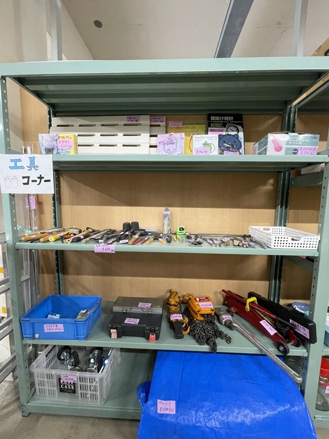 商品が置かれたラックに工具コーナーと書かれた手作りのポップが貼られた売り場の写真