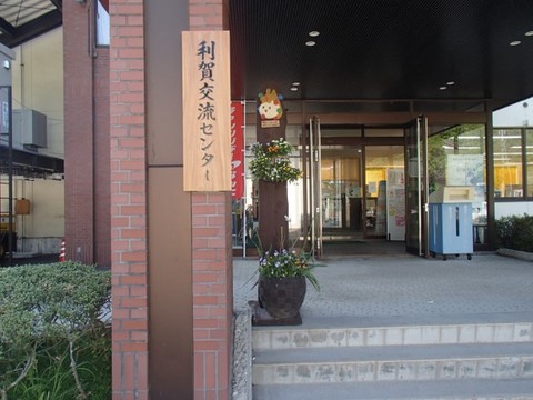 木に南砺市利賀交流センターと書かれた看板が貼ってある入り口を撮影している写真