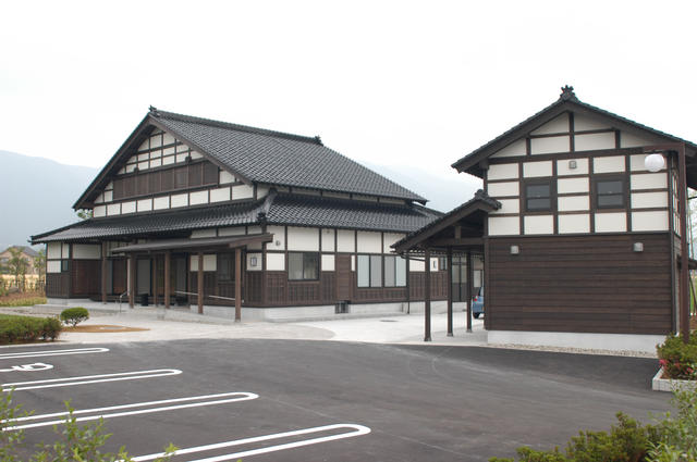 白と茶色の外壁の母屋と納屋に分かれた木造2階建てのあずまだち高瀬を全体的に撮影した写真