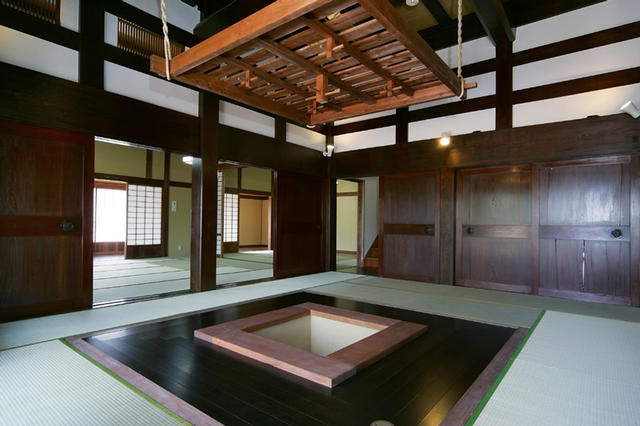 綺麗に整備された囲炉裏が部屋中央にある和室の広間を撮影した写真