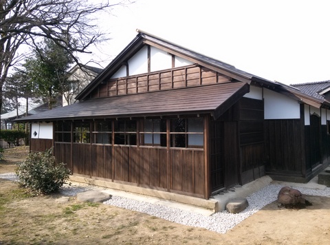 栖霞園内にある三角屋根で木造の茶室建築物の外観を写した写真