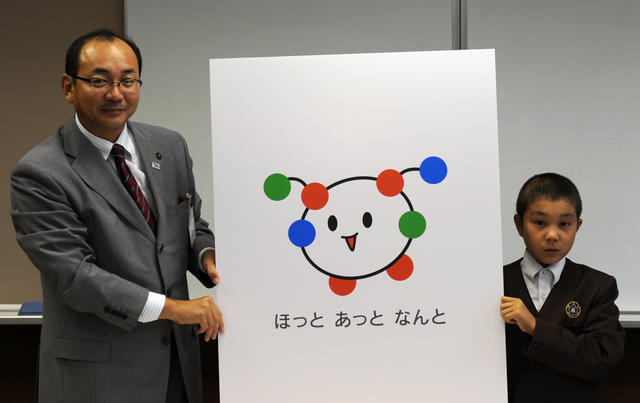 市長と最優秀賞の透衣くんが南砺市ブランドマークが描かれたボードを一緒に持っている写真