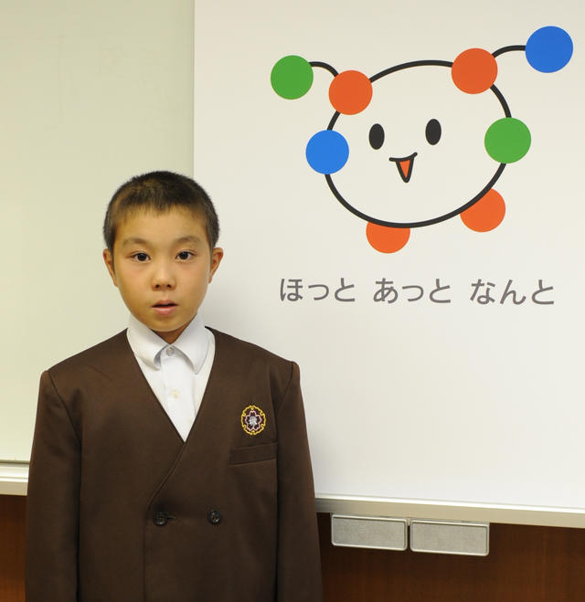 最優秀賞に選ばれた透衣くんと南砺市ブランドマークが一緒に写っている写真