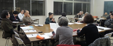 並べられた長机を囲むように座り関係者の方々が会議をしている様子の写真