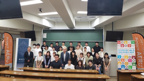 任命式に参加した学生と関係者が3列に並び記念撮影をしている写真