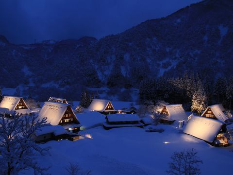雪が積もり日が暮れた菅沼合掌造りの集落の合掌造りがライトアップされている写真