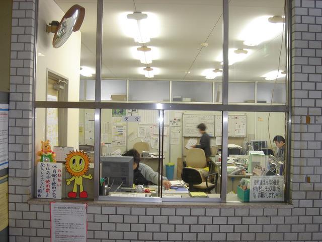 窓の奥に受付で働いている人達が見えている福光体育館の写真