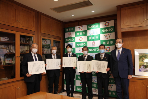 表彰企業5事業者の方が表彰状を持ち市長と並んで記念撮影をしている写真