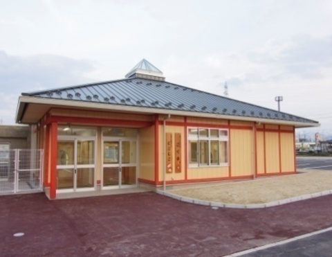 薄いオレンジ色の外壁で、平屋建ての南砺市立子育て支援センター「にこにこ」の外観写真