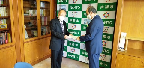 尾治明委員長が田中市長に答申書の手渡しをしている写真